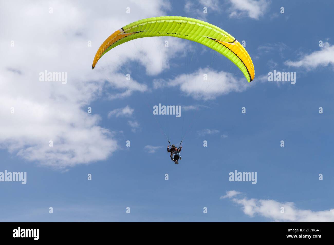 Gudauri, Georgia - 1. Mai 2019: Gleitschirmflieger fliegen an einem sonnigen Tag im blauen Himmel Stockfoto