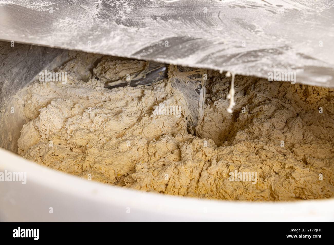 Teig für Brot in einem Kneter in einer Bäckerei machen. Industriemischer zum Kneten von Teig. Stockfoto