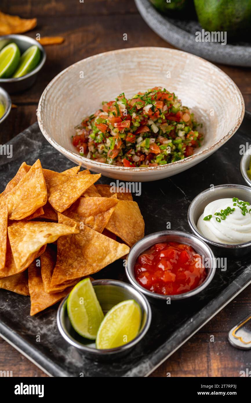 Pico de gallo aus mexikanischer Küche mit eintauchenden Saucen auf Holztisch Stockfoto