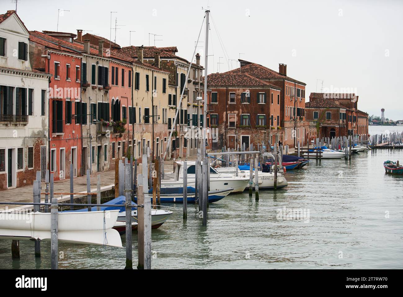 Günstige venezianische Wohngebäude und kleine Boote am alten Pier auf der Insel Guidecca. Venedig - 6. Mai 2019 Stockfoto