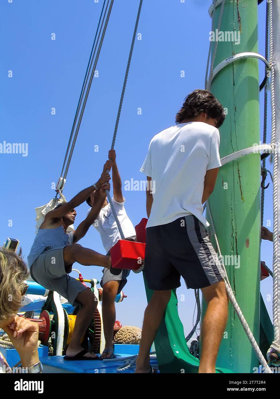 Seixal, Portugal. 20. Juni 2023: Segler heben oder setzen die Hauptsegel auf dem Segelboot Amoroso, einem historischen, typischen oder traditionellen Varino Typ T Stockfoto