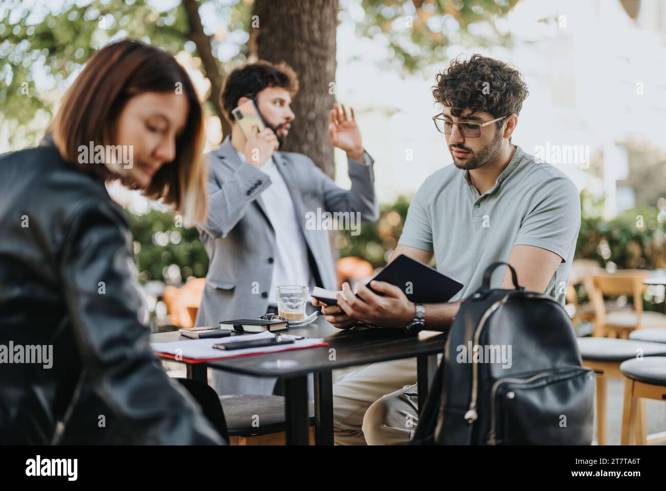 Geschäftsleute diskutieren in einer Coffee Bar in der Stadt über erfolgreiche Geschäftsausweitungen, Vertriebsstrategien und Budgetmanagement. Stockfoto