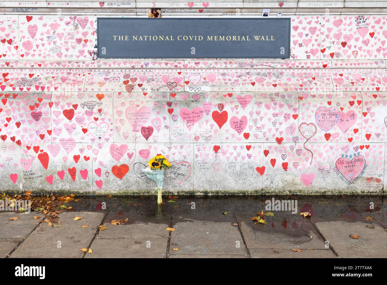 Die National COVID Memorial Wall am Südufer der Themse mit Plakette und Blumenstrauß, London, Großbritannien Stockfoto