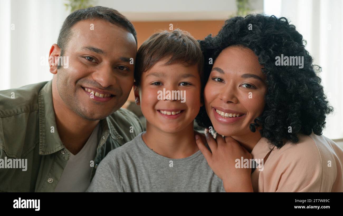 Glückliche multirassische afroamerikanische liebevolle Mutter und Vater küssen kleinen Jungen auf die Wangen Adoption Kinderbetreuung Familie binden fürsorgliche Eltern umarmen Kuscheln Stockfoto