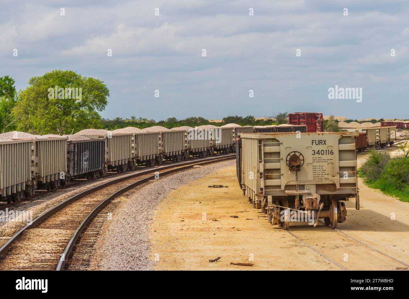 Zuggleise und geparkte Güterzugwagen entlang der Central Texas Zugstrecke von Austin nach Burnet. Schienen, die von Hill Country Flyer Tourist Train Ride genutzt werden. Stockfoto