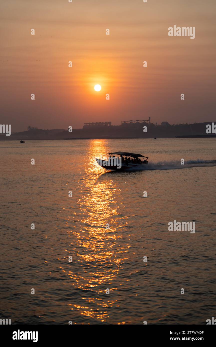 Wunderschöne goldene Stunde Sonnenuntergang am Amazonas Tapajos Fluss mit einem Schnellboot und landwirtschaftlichen Silos, um Sojabohnen zu lagern. Umweltbegriff, Ökologie. Stockfoto