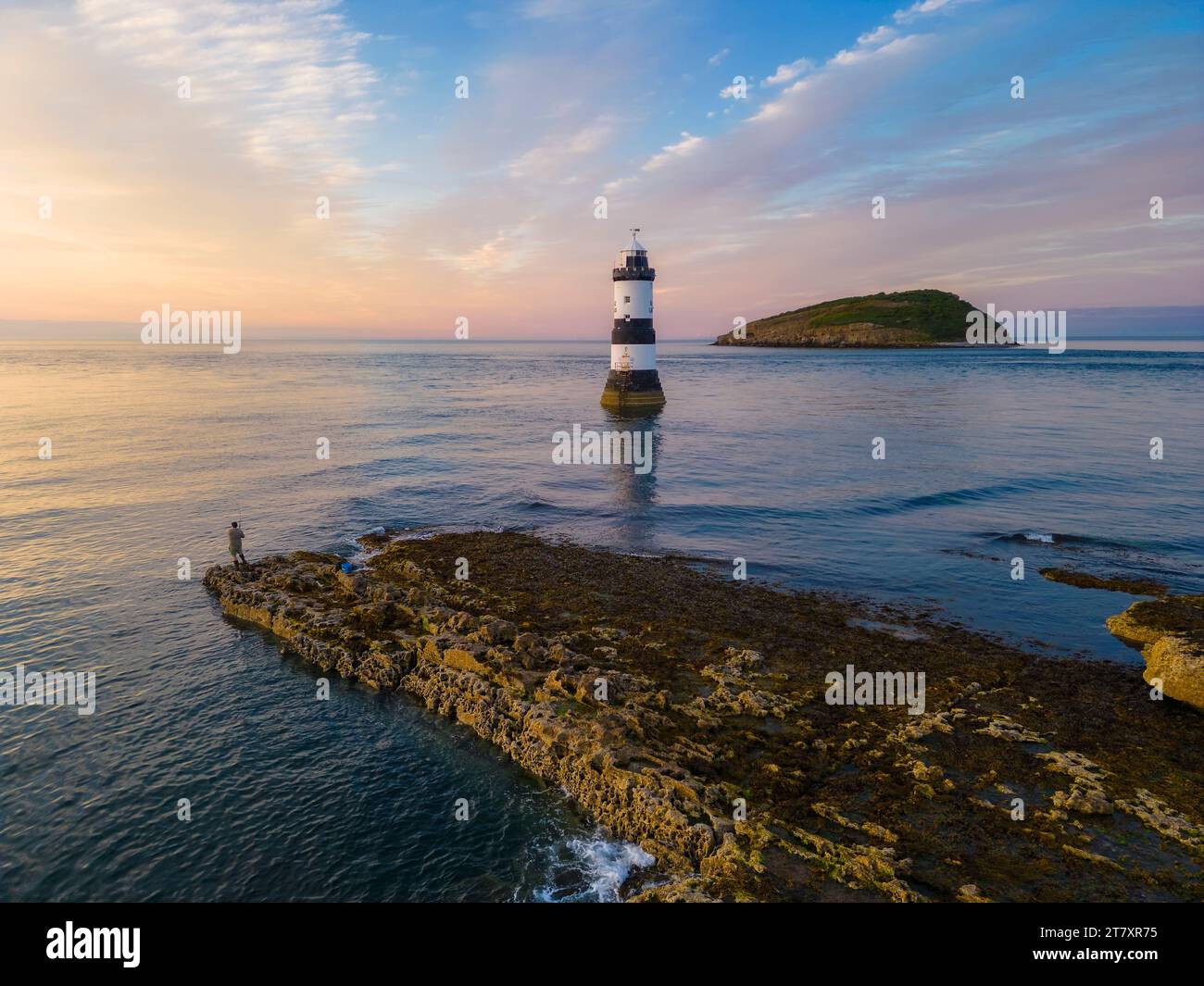 Fisherman at Trwyn du Lighthouse bei Sonnenuntergang im Sommer, Beaumaris, Wales, Großbritannien, Europa Stockfoto