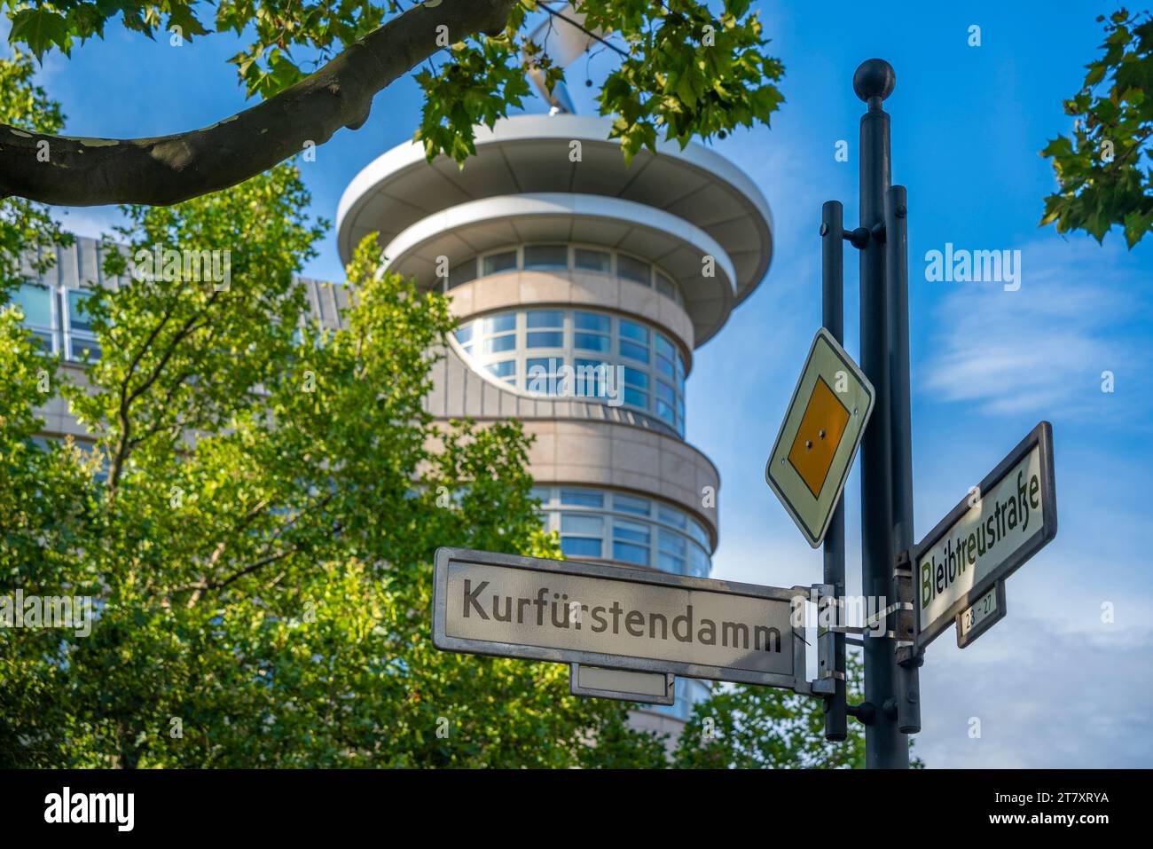 Blick auf Schild und Gebäude auf dem von Bäumen gesäumten Kurfurstendam in Berlin, Deutschland, Europa Stockfoto