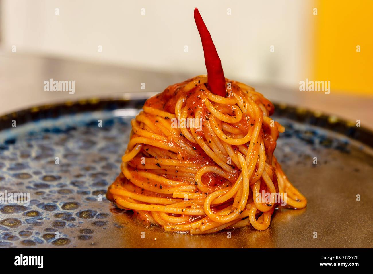 Spaghetti all'arrabbiata typische italienische Pasta mit Tomatensauce, Knoblauch, Petersilie und scharfem Chili-Pfeffer, Nahaufnahme auf schwarzem Teller Stockfoto