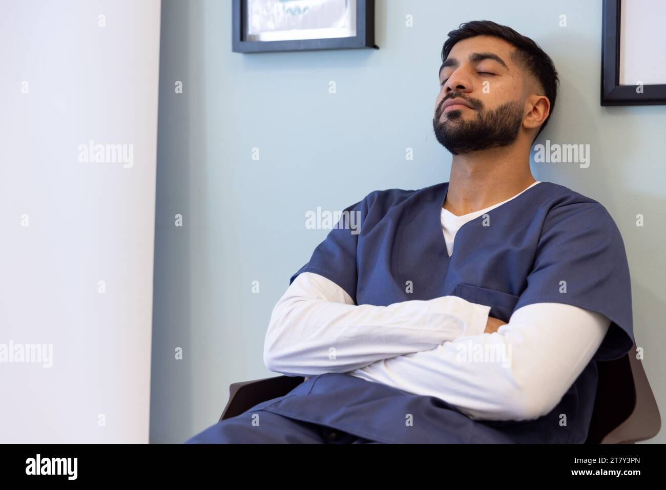 Birassischer männlicher Arzt macht ein Nickerchen im Wartezimmer des Krankenhauses Stockfoto