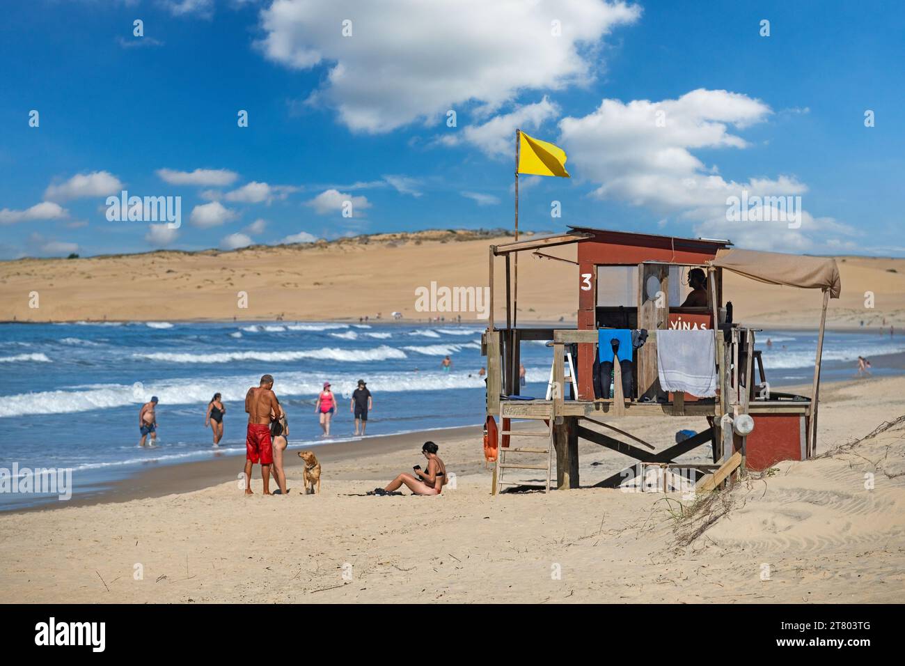 Rettungsschwimmer Turm und Touristen, die am Strand von Barra de Valizas, Badeort / Balneario entlang des Atlantischen Ozeans, Rocha, Uruguay, Südamerika wandern Stockfoto