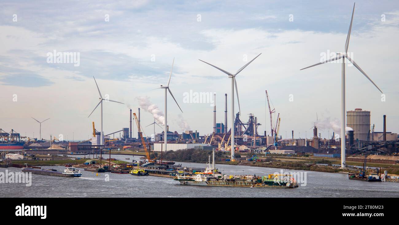 Windturbinen an einem Industriehafen mit verankerten Lastkähnen, Produktionsstätten, an der Amstel, die nach Amsterdam führt Stockfoto