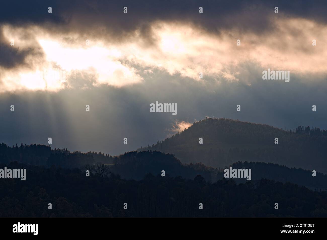 Dramatischer Abendhimmel mit Sonnenstrahlen und Wolken über Hügeln und Bergen in der Nähe von Roznov Pod Radhostem, Tschechien. Spätherbst. Stockfoto