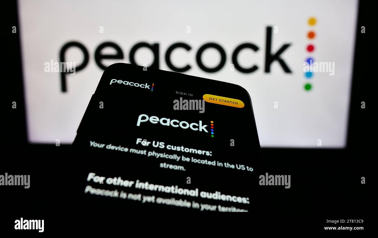 Smartphone mit Website des US-amerikanischen Videostreaming-Unternehmens Peacock TV LLC vor dem Geschäftslogo. Fokussieren Sie sich oben links auf der Telefonanzeige. Stockfoto