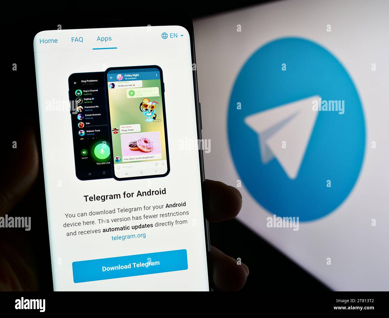 Person mit Mobiltelefon und Webseite des Instant Messaging-Dienstes Telegram Messenger vor dem Logo. Konzentrieren Sie sich auf die Mitte des Telefondisplays. Stockfoto