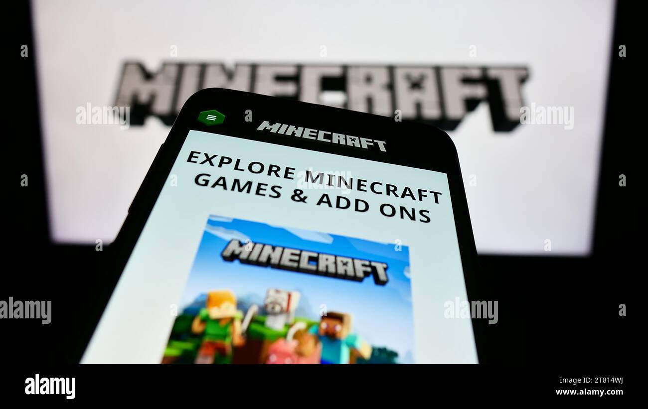 Mobiltelefon mit Website des Sandbox-Videospiels Minecraft vor dem Logo. Fokussieren Sie sich oben links auf der Telefonanzeige. Stockfoto