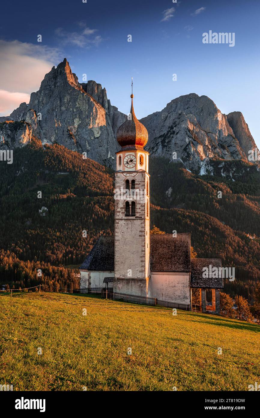 Seis am Schlern, Italien - berühmter St. Valentinskirche und Berg Sciliar im Hintergrund. Idyllische Berglandschaft in den italienischen Dolomiten mit B Stockfoto