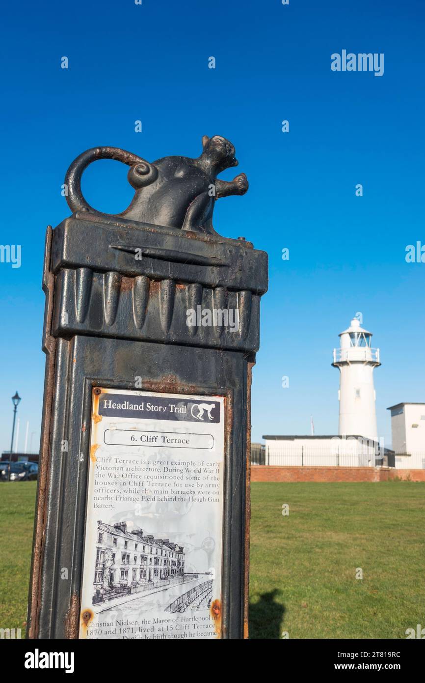 Eine Informationstafel auf dem Hartlepool Headland Story Trail mit einem Affen und dem Heugh Light im Hintergrund, England, Großbritannien Stockfoto
