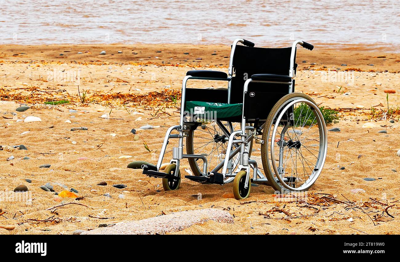 Ein Rollstuhl am Strand am Meer. Stockfoto
