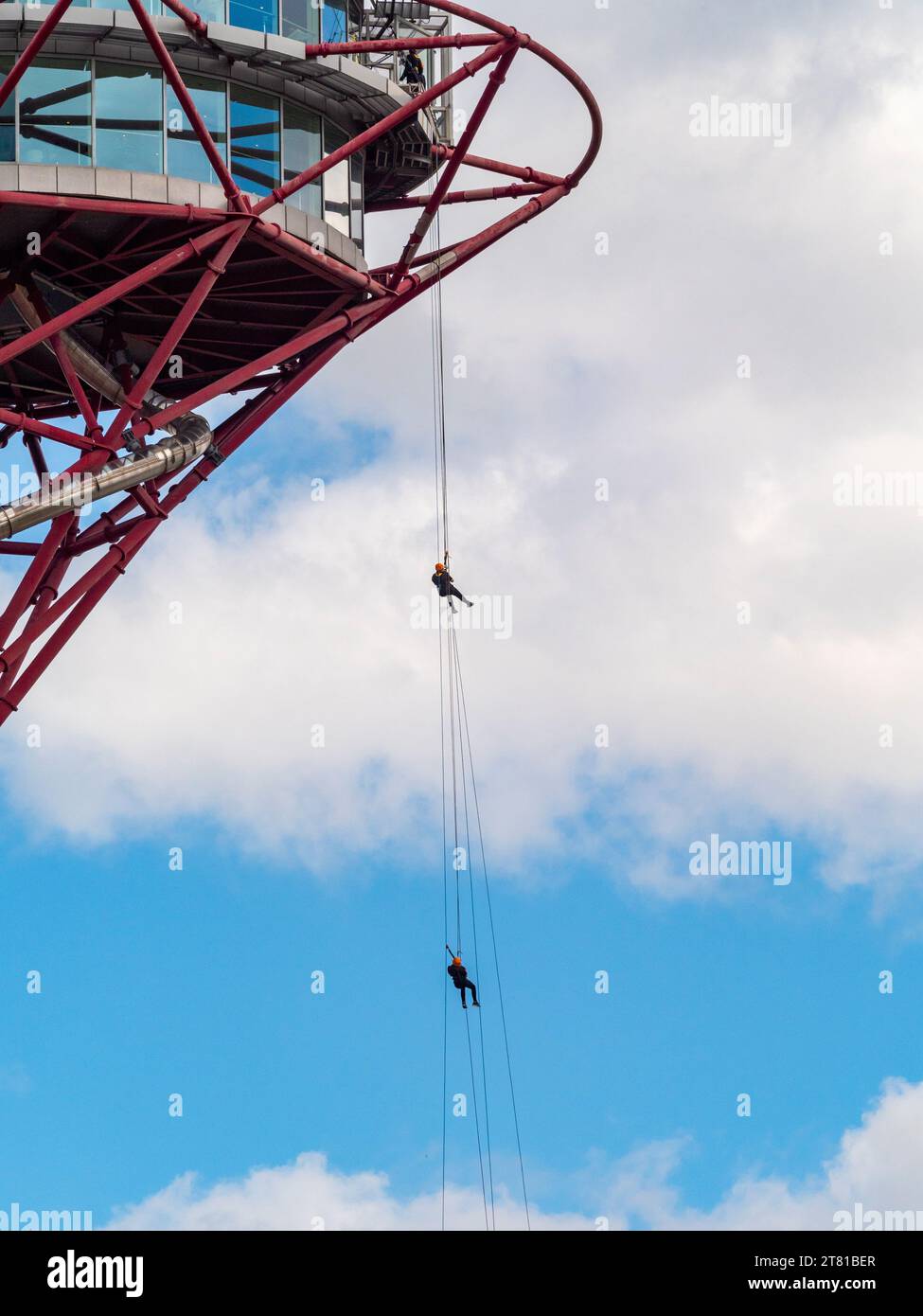 Zwei Personen, die sich frei vom ArcelorMittal Orbit im Olympischen Park abseilen. Stratford. London. Stockfoto