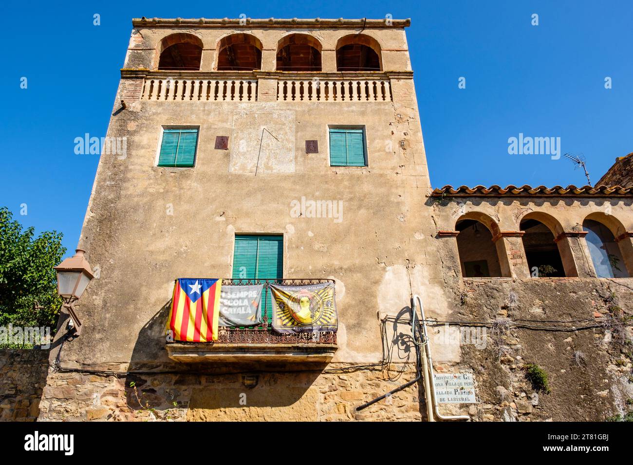 Katalanische estelada inoffizielle Sternenflagge und Banner, die katalanische Unabhängigkeit fördern, hängen von einem Balkon im Dorf Pals, Katalonien, Spanien Stockfoto