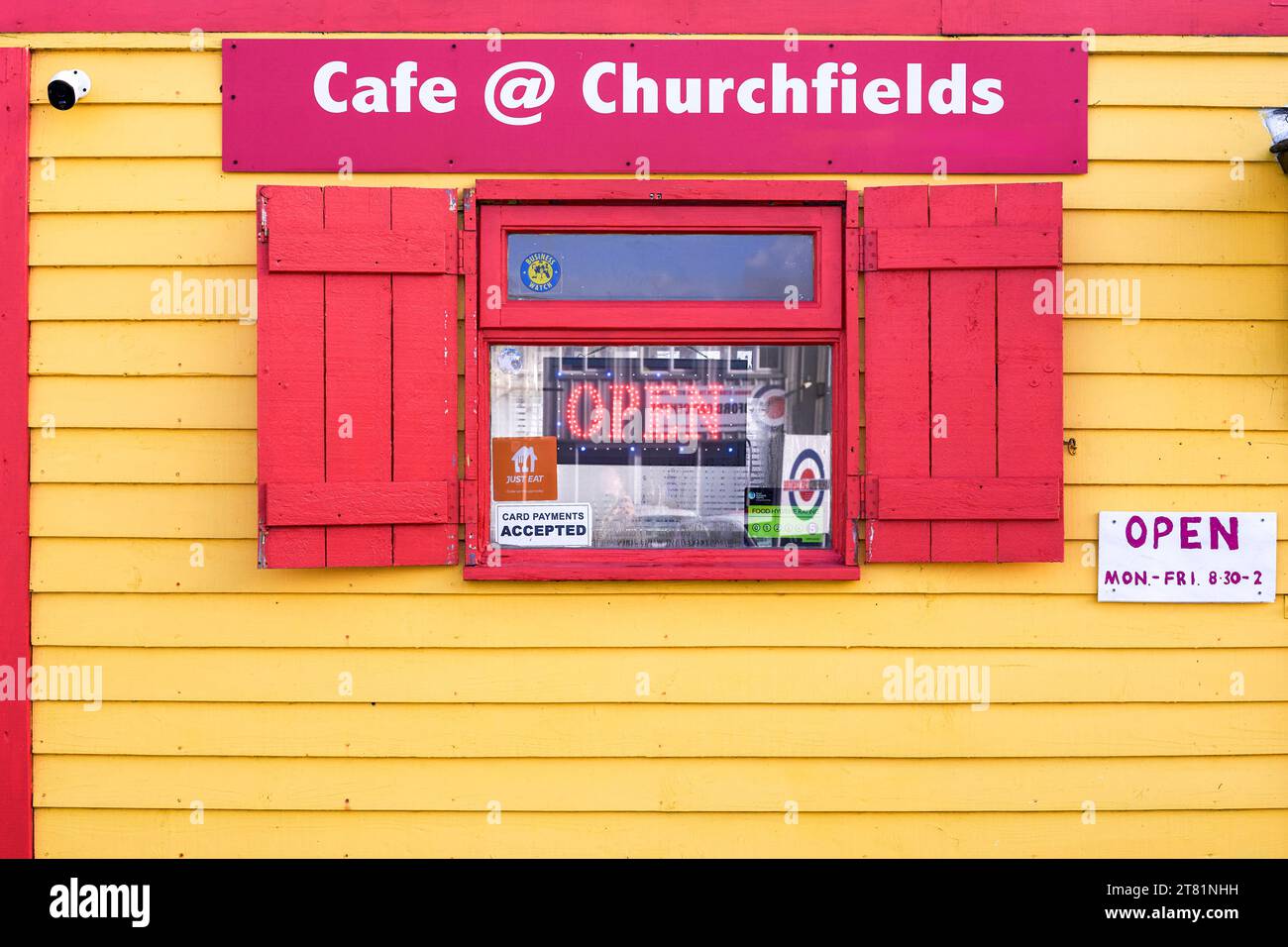 Fenster in einem gelb-rot bemalten Holzcafé Stockfoto