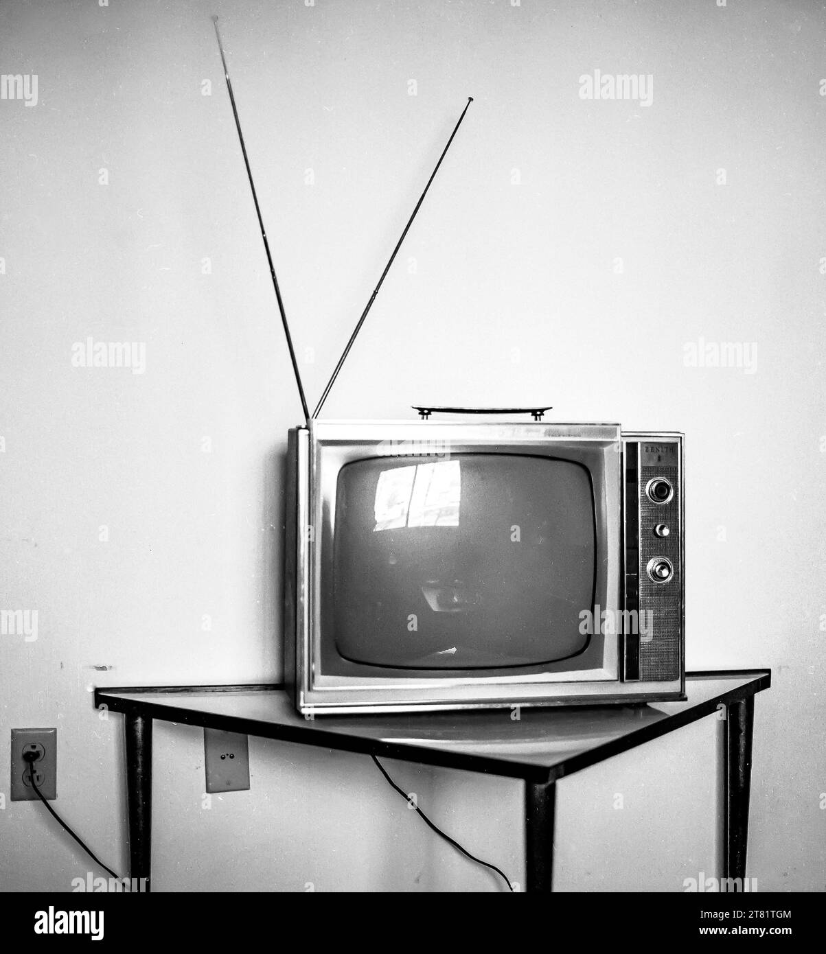 Tragbarer Fernseher im Retro-Stil mit Antenne auf kleinem Moteltisch Kopierraum Stockfoto