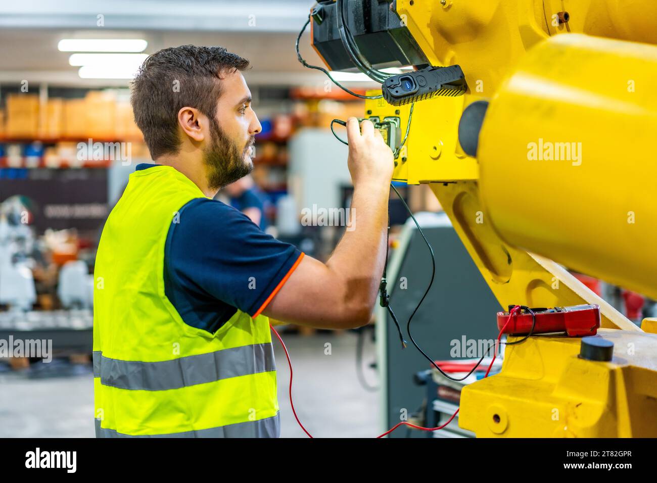 Maschinenbauingenieur inspiziert einen mechanischen Arm an einer industriellen Produktionslinie Stockfoto