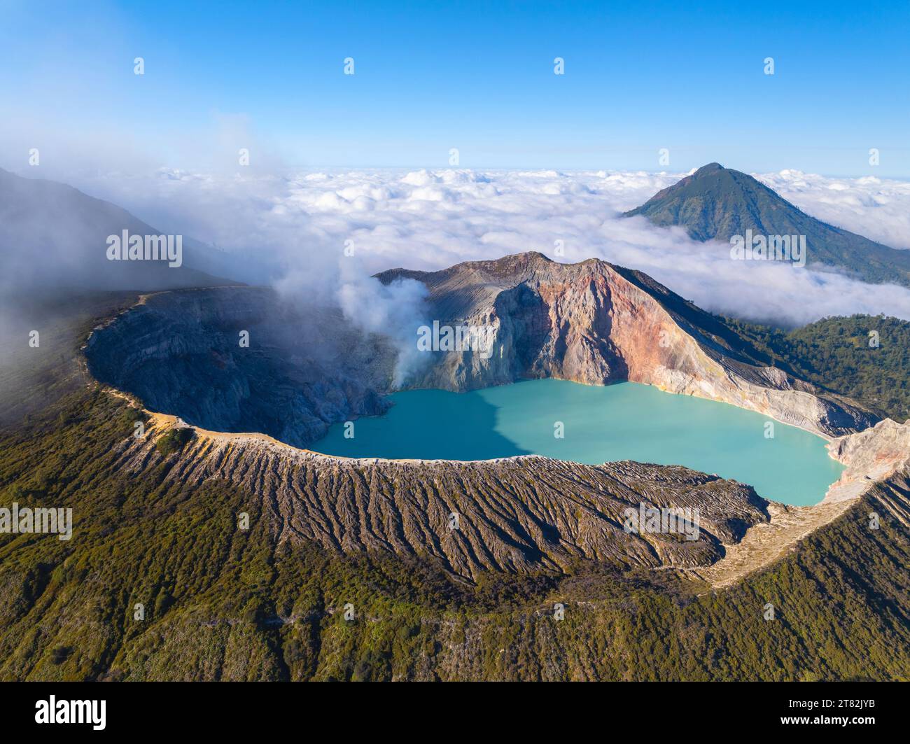 Aus der Vogelperspektive auf die Felsenklippe am Kawah Ijen Vulkan mit türkisfarbenem Schwefelwassersee bei Sonnenaufgang. Fantastischer Blick auf die Naturlandschaft in Ost-Java, Indonesien. Natu Stockfoto