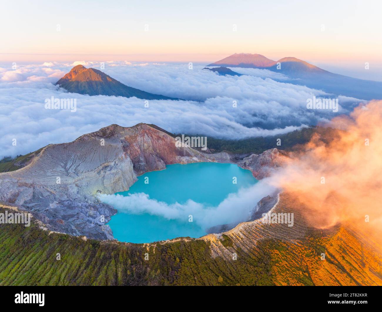 Aus der Vogelperspektive auf die Felsenklippe am Kawah Ijen Vulkan mit türkisfarbenem Schwefelwassersee bei Sonnenaufgang. Fantastischer Blick auf die Naturlandschaft in Ost-Java, Indonesien. Natu Stockfoto