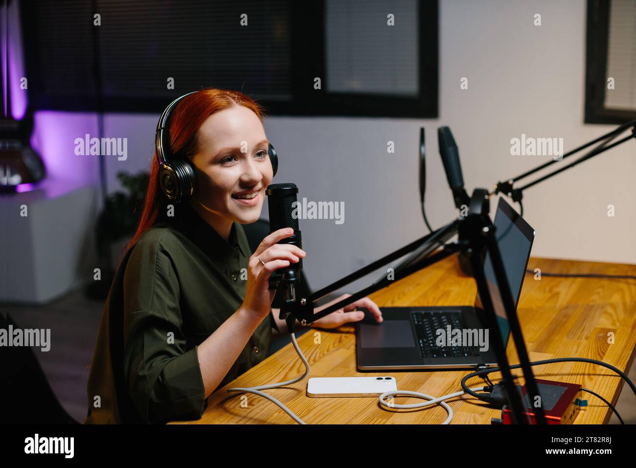 Die weibliche Radiomoderatorin spricht während der Sendung in das Mikrofon. Online-Blogger während des Streams. Stockfoto