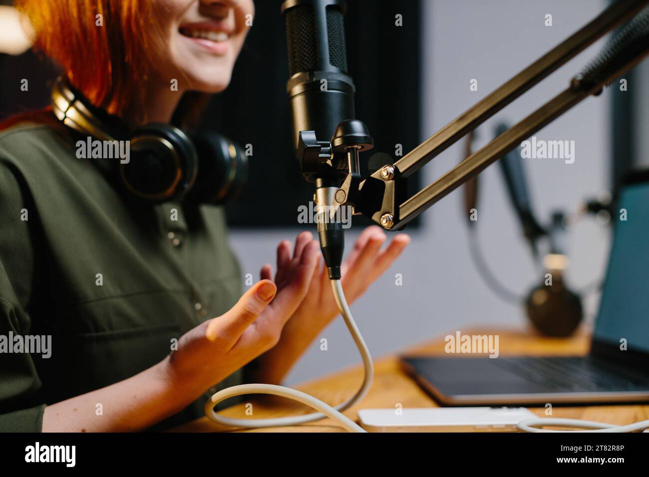 Die weibliche Radiomoderatorin spricht während der Sendung in das Mikrofon. Online-Blogger während des Streams, Nahaufnahme. Stockfoto
