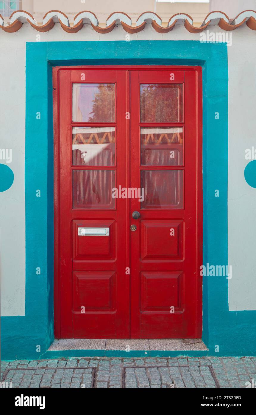Winzige Tür mit lebhaften Farben im Vila Nova de Milfontes Haus. Kleine malerische Stadt an der Küste von Alentejo, Portugal Stockfoto
