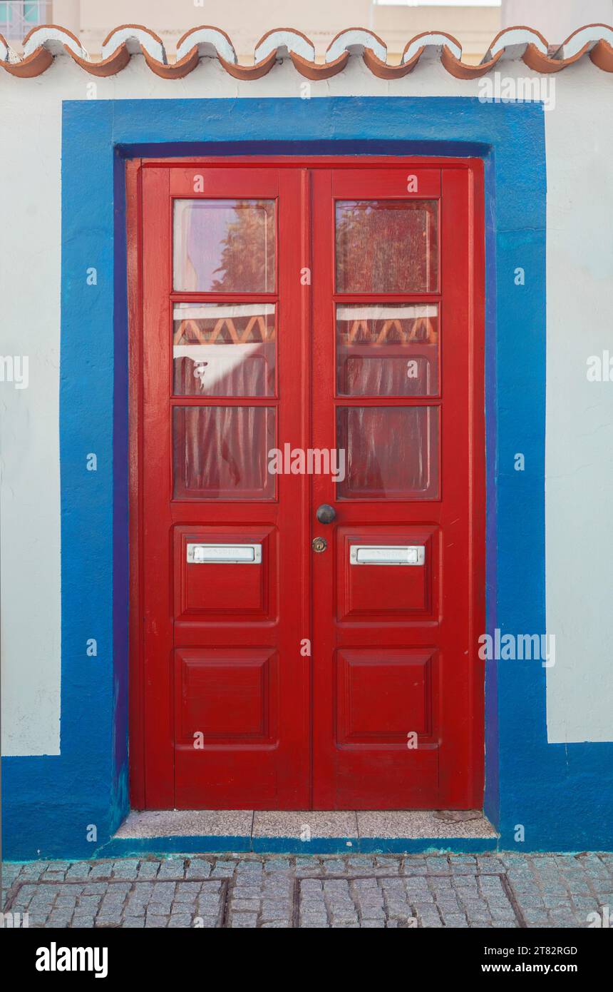 Winzige Tür mit lebhaften Farben im Vila Nova de Milfontes Haus. Kleine malerische Stadt an der Küste von Alentejo, Portugal Stockfoto