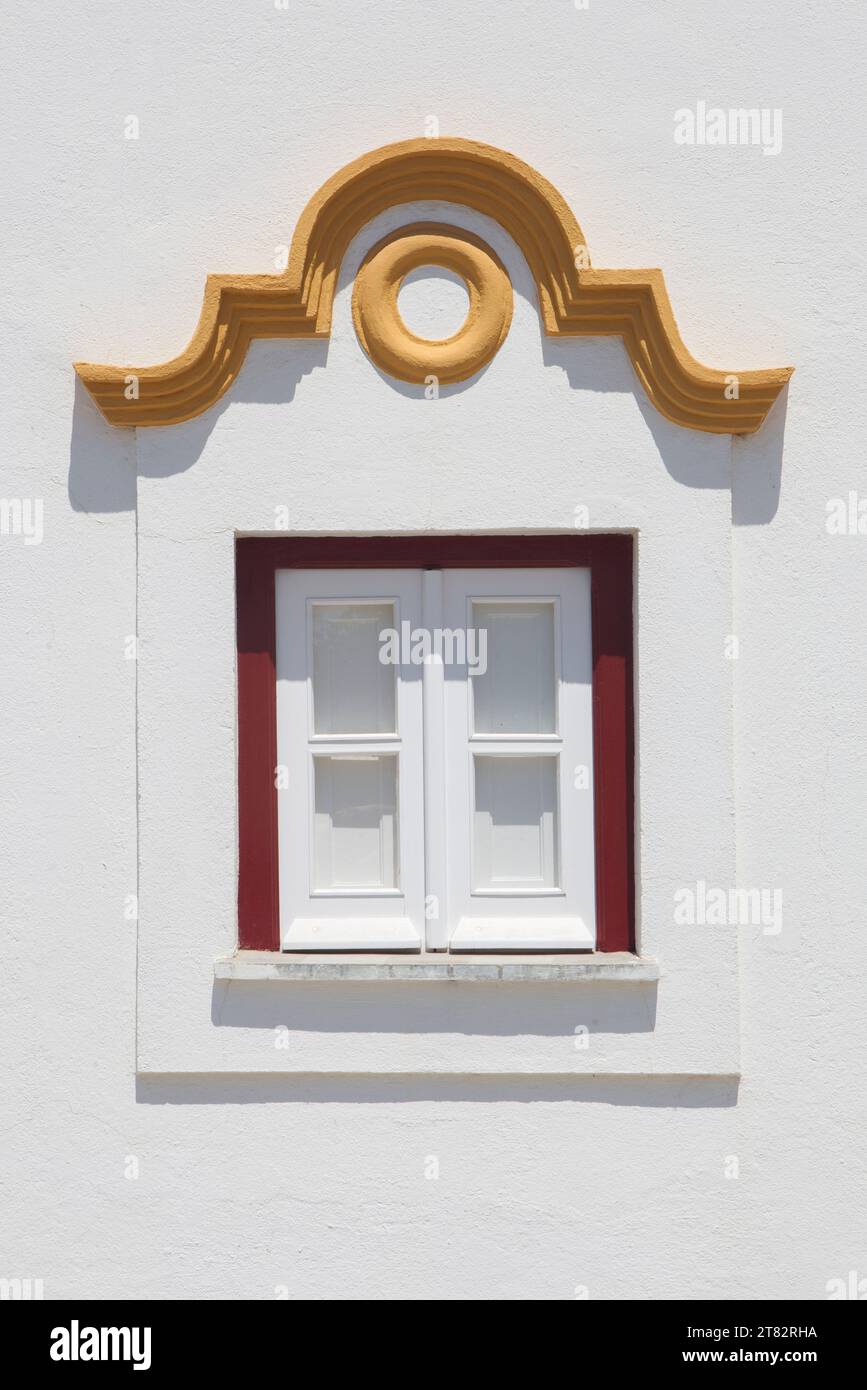 Winziges Fenster mit lebhaften Farben im Haus Vila Nova de Milfontes. Kleine malerische Stadt an der Küste von Alentejo, Portugal Stockfoto