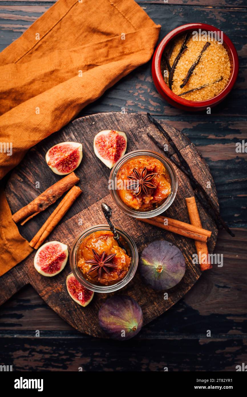 Hausgemachte Feigenmarmelade oder Gelee in einem Glas mit Zimt, Vanille und braunem Zucker Stockfoto