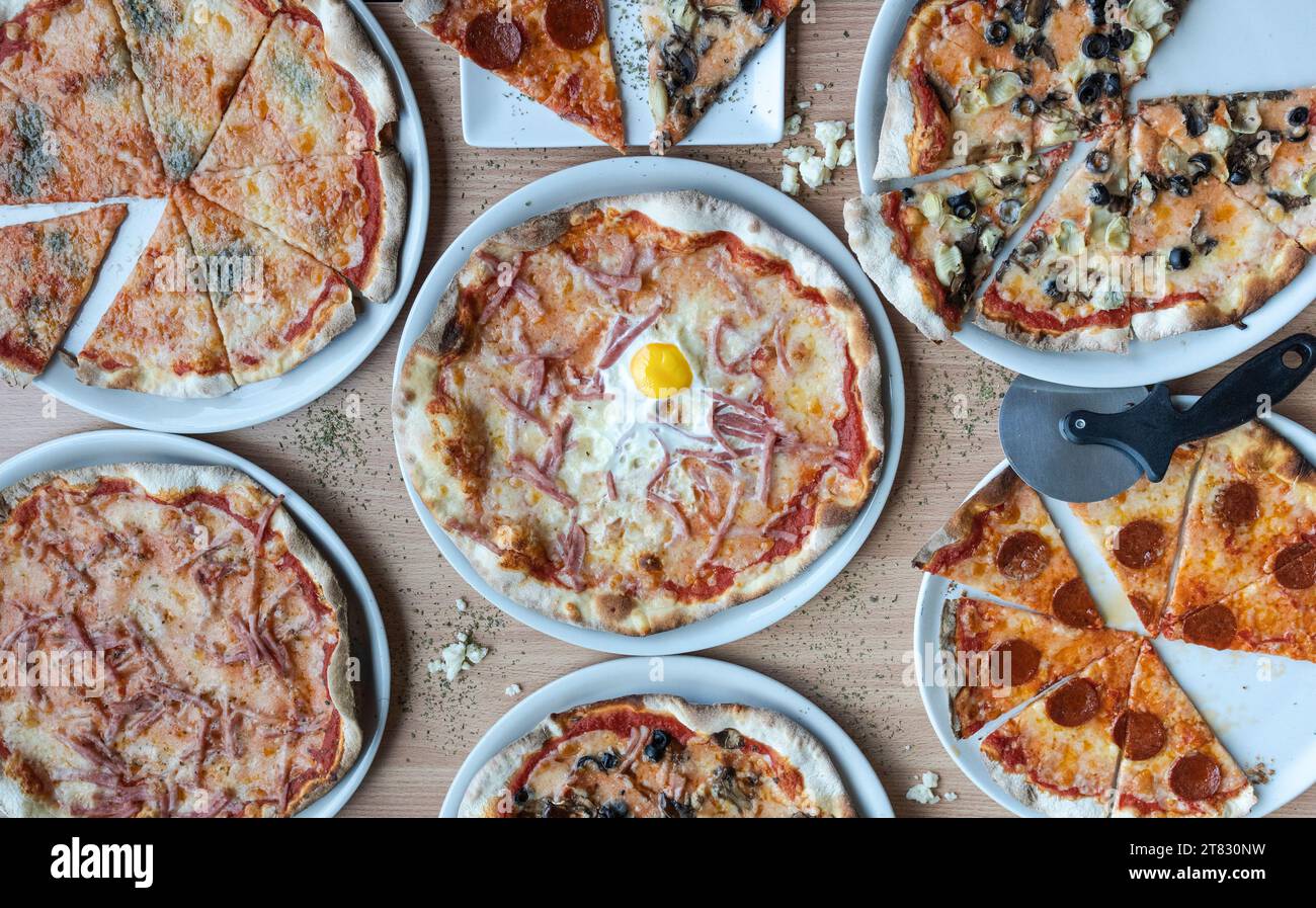 Verschiedene Pizzaden auf einem Holztisch. Stockfoto