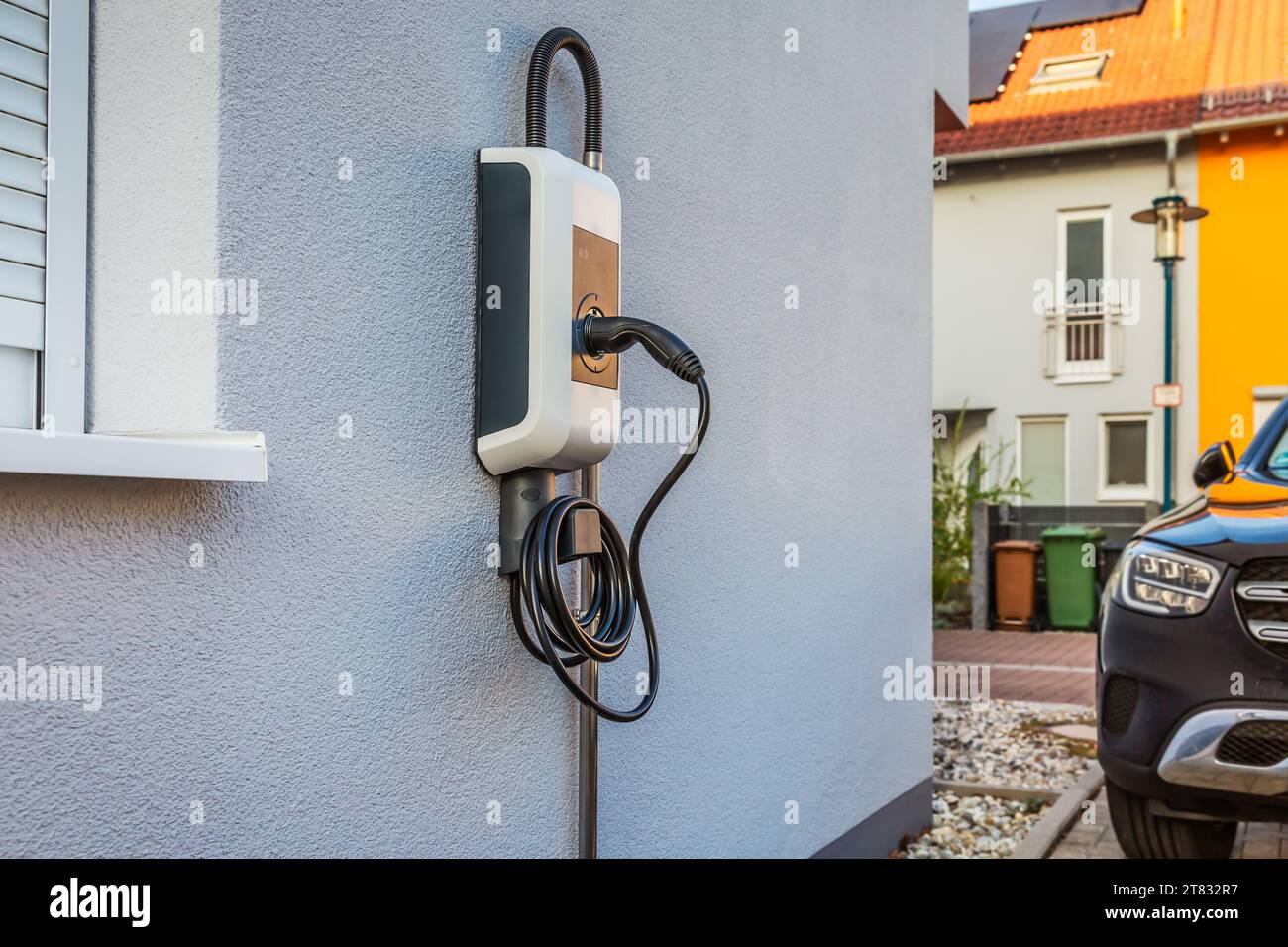 Wallbox an einer Hauswand für komfortables Aufladen des Elektroautos Stockfoto