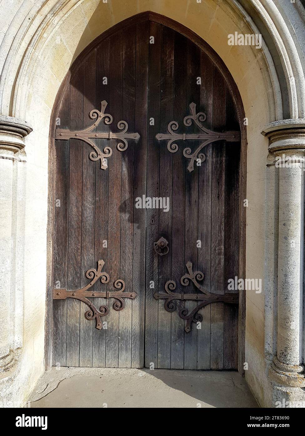 Nahaufnahme einer historischen hölzernen Kirchentür in einem Steineingang. Stockfoto
