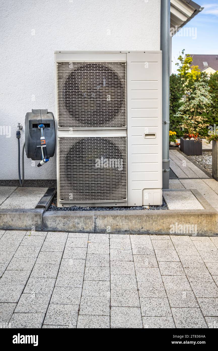 Zwei Luftquellenwärmepumpen außerhalb des modernen Familienhauses installiert, Konzept der Wärmepumpe für umweltfreundliche erneuerbare Energien Stockfoto