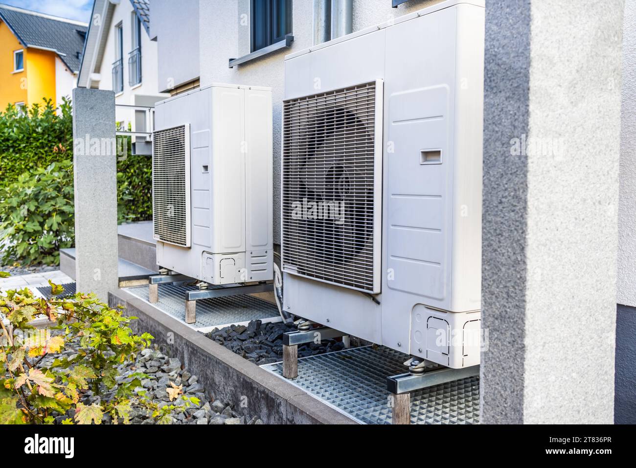 Zwei Luftquellenwärmepumpen außerhalb des modernen Familienhauses installiert, Konzept der Wärmepumpe für umweltfreundliche erneuerbare Energien Stockfoto