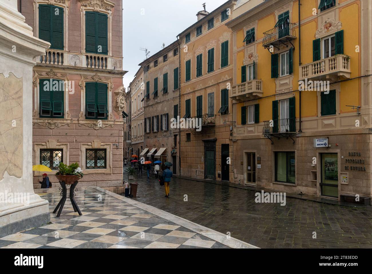 Via Roma von der Stiftskirche San Giovanni Battista (17. Jahrhundert) in der Altstadt an einem regnerischen Tag, Finale Ligure, Savona, Ligurien, Italien Stockfoto