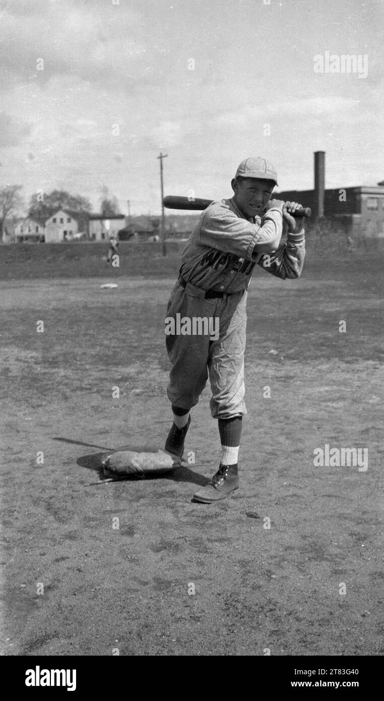 1930er Jahre, historisch, ein Teenager, der ein Baseball-Outfit trägt und mit seinem Baseballschläger steht, USA. Der Baseball-Sport gilt als der Nationalsport der Vereinigten Staaten, der zuerst in Cooperstown, NY, gegründet wurde, obwohl viele der Ansicht sind, dass er aus einem englischen Spiel namens Rounders aus dem 18. Jahrhundert entwickelt wurde. Stockfoto