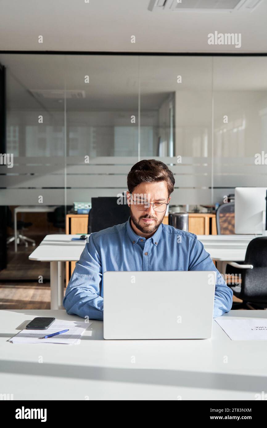 Geschäftiger Geschäftsmann mit Laptop, der im Büro am Computer arbeitet. Stockfoto