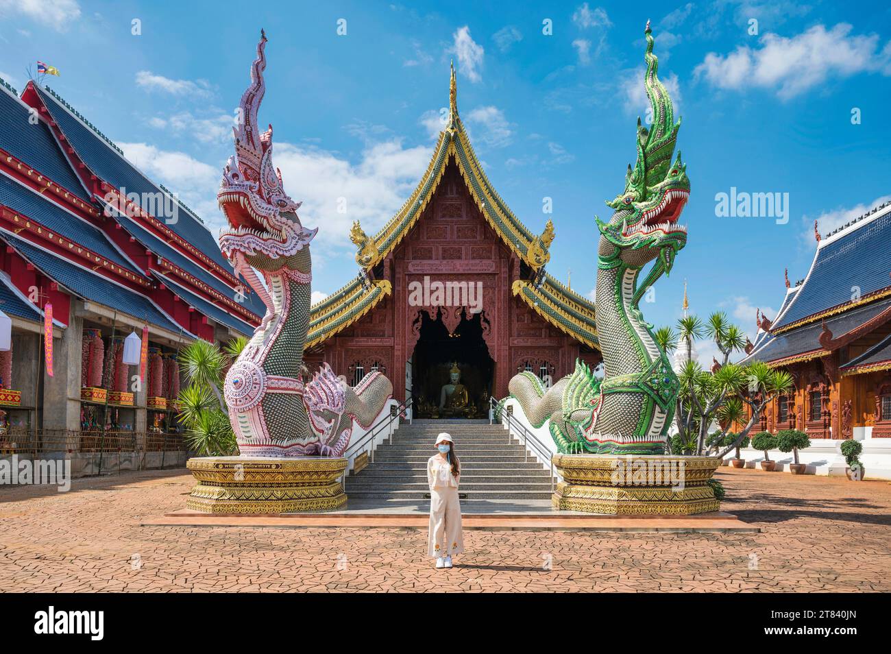 Asiatische Touristen kommen zum Gottesdienst im Wat Ban den oder Wat den Salee Sri Muang Gan, dem Tempel im Lanna-Stil und der bunten Statuenskulptur am sonnigen Tag A Stockfoto