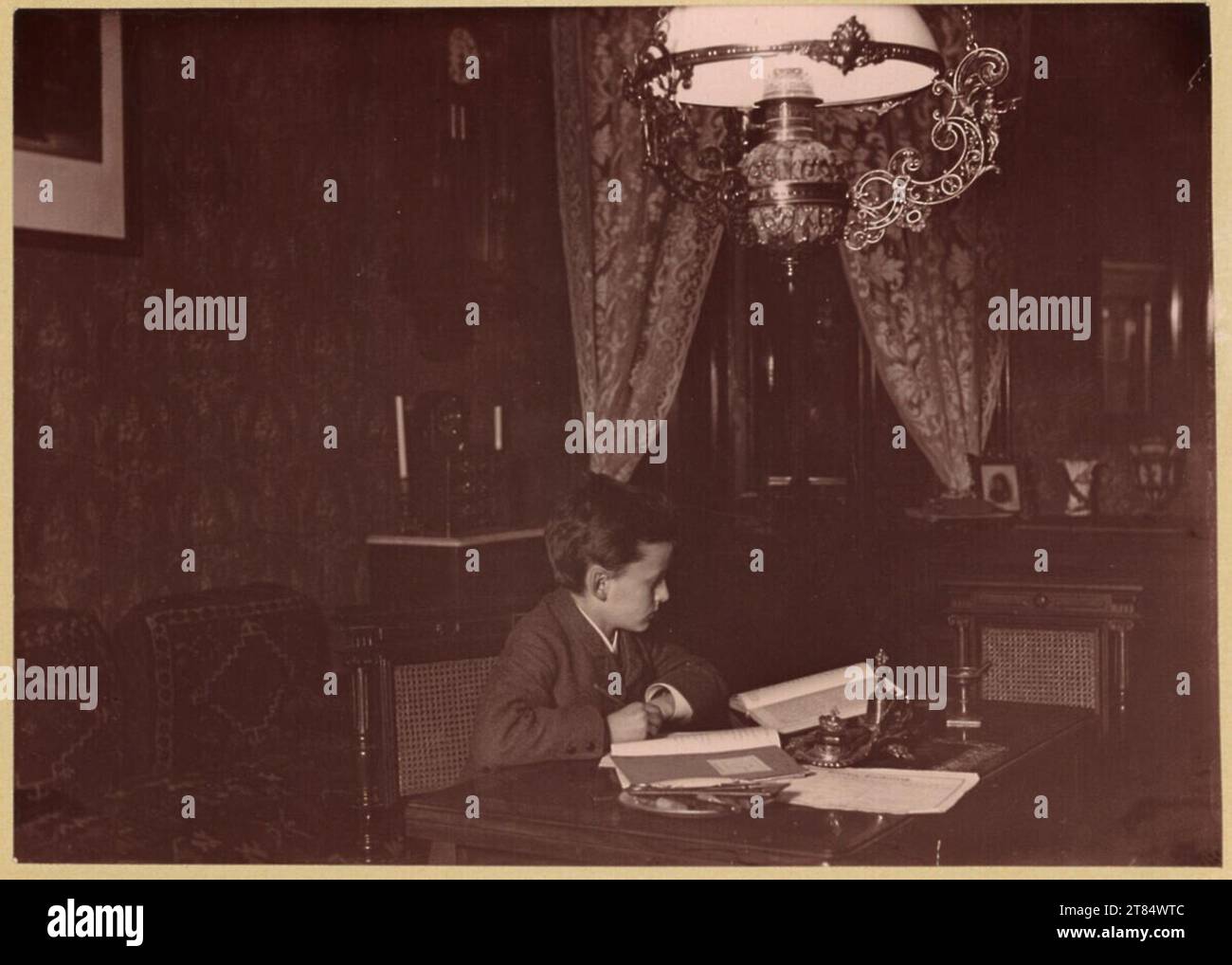Julius Hofmann Junge sitzt am Schreibtisch und macht seine Hausaufgaben. Albuminpapier, auf der Schachtel 1889 , 1889 Stockfoto