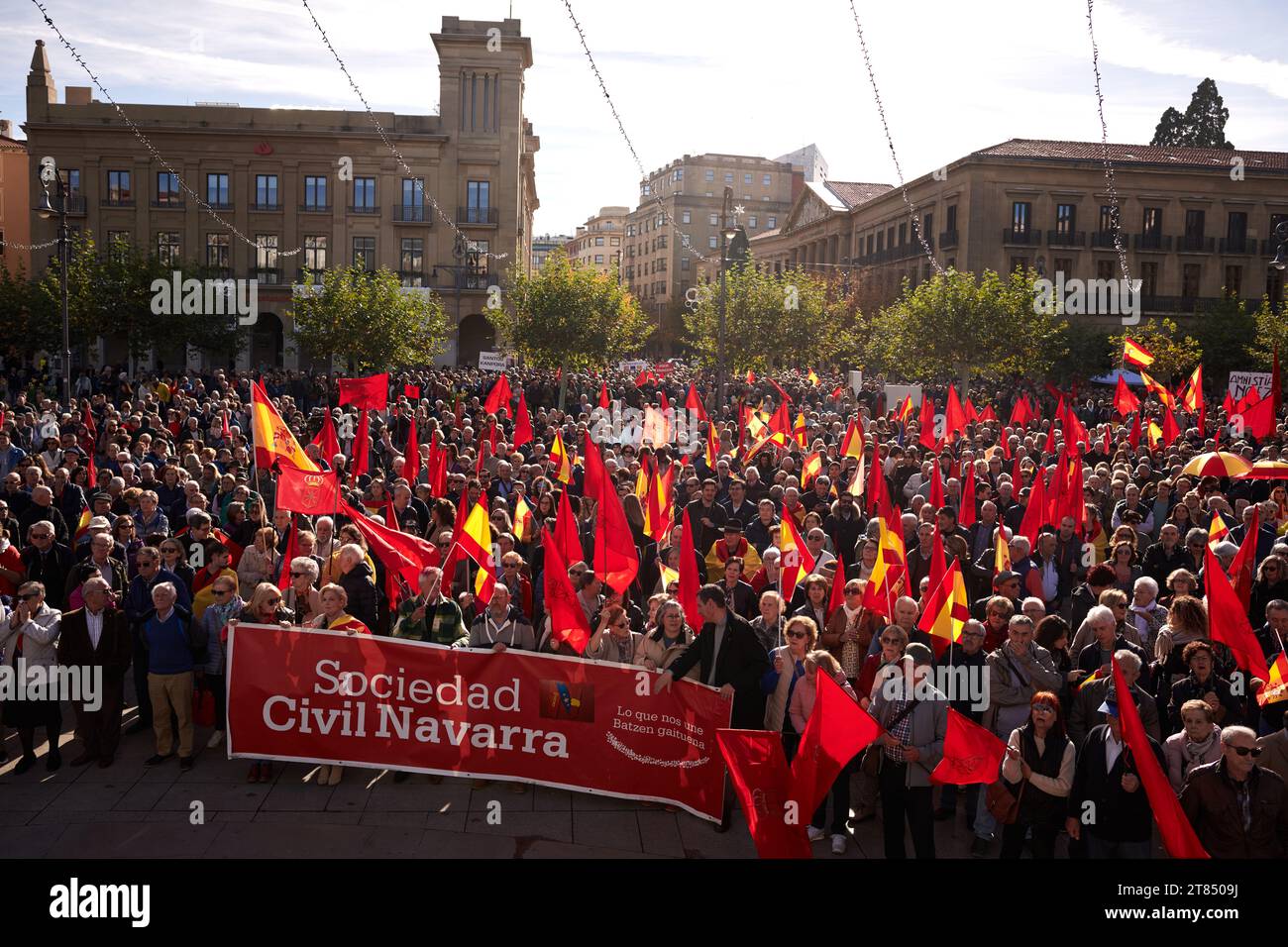 Pamplona, Spanien. November 2023. Während der Demonstration gegen Amnestie versammeln sich Demonstranten mit einem Banner und Fahnen auf der Plaza del Castillo. Der Präsident Spaniens, Pedro Sánchez, stimmte einer Amnestievereinbarung mit den Separatisten Kataloniens zu, um zum spanischen Präsidenten wiedergewählt zu werden. Quelle: SOPA Images Limited/Alamy Live News Stockfoto