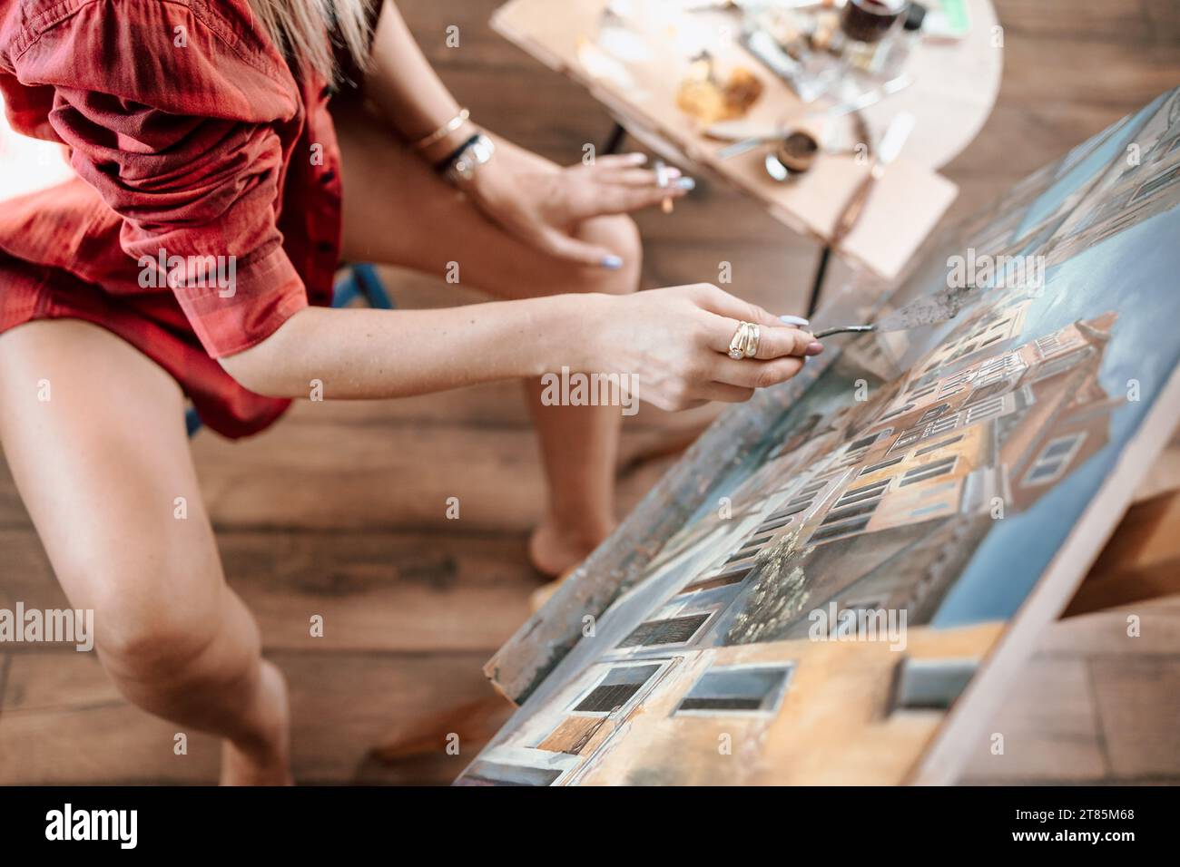 Junge Frau, die in ihrem Atelier malt, kein Gesicht, Nahaufnahme der Hand Stockfoto