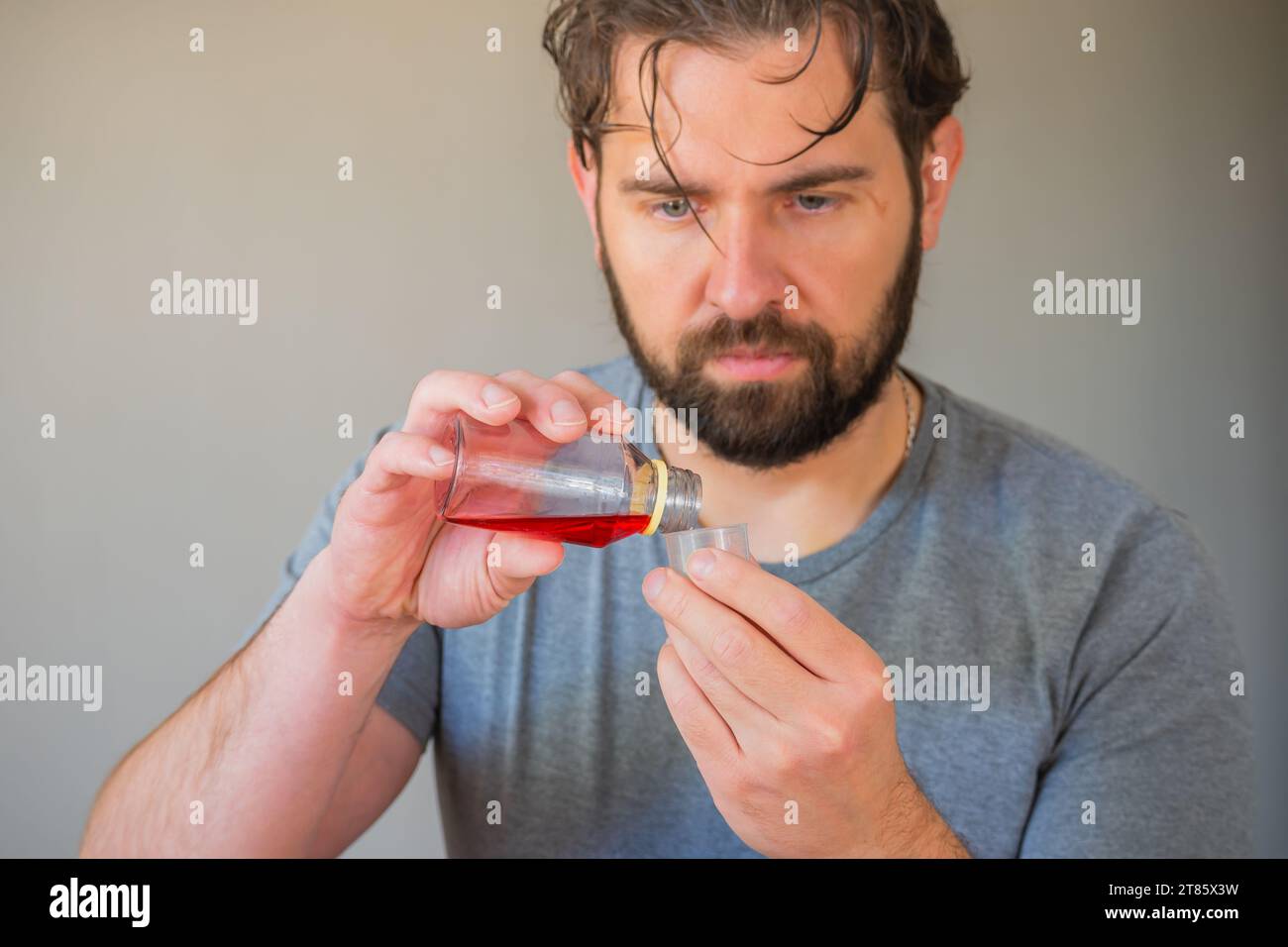 Person, die Sirup in einen Messbecher gießt. Stockfoto