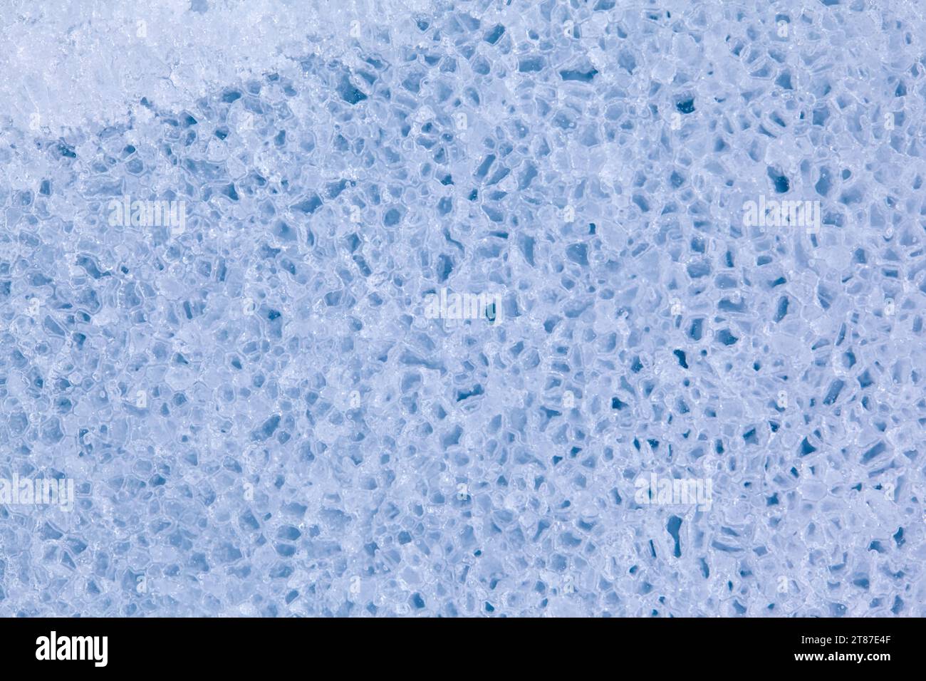 Die Konsistenz der Wintereisoberfläche in Form von polygonalen Mustern. Blauer natürlicher Eishintergrund. Stockfoto